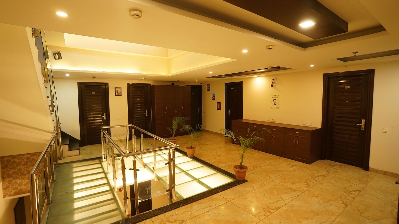 The interior of Hotel Dreamland Chandigarh, featuring the lobby area with a staircase, a reception desk, and several doorways.