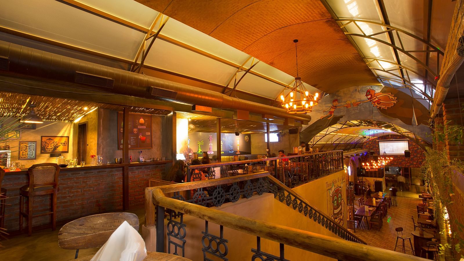 view of the upper floor of a restaurant with tables and chairs beside the walls and a staircase leading downstairs - Hotel Fountain Tree By TGI - JP Nagar, Bangalore