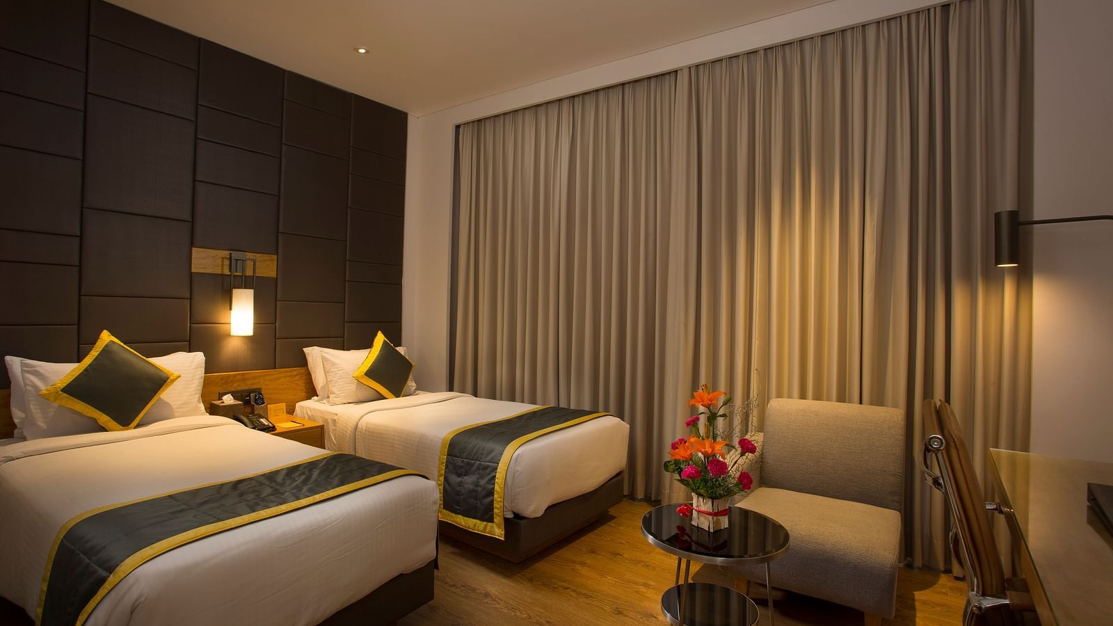 a bedroom with two single beds and a sofa - Hotel Fountain Tree By TGI - JP Nagar, Bangalore