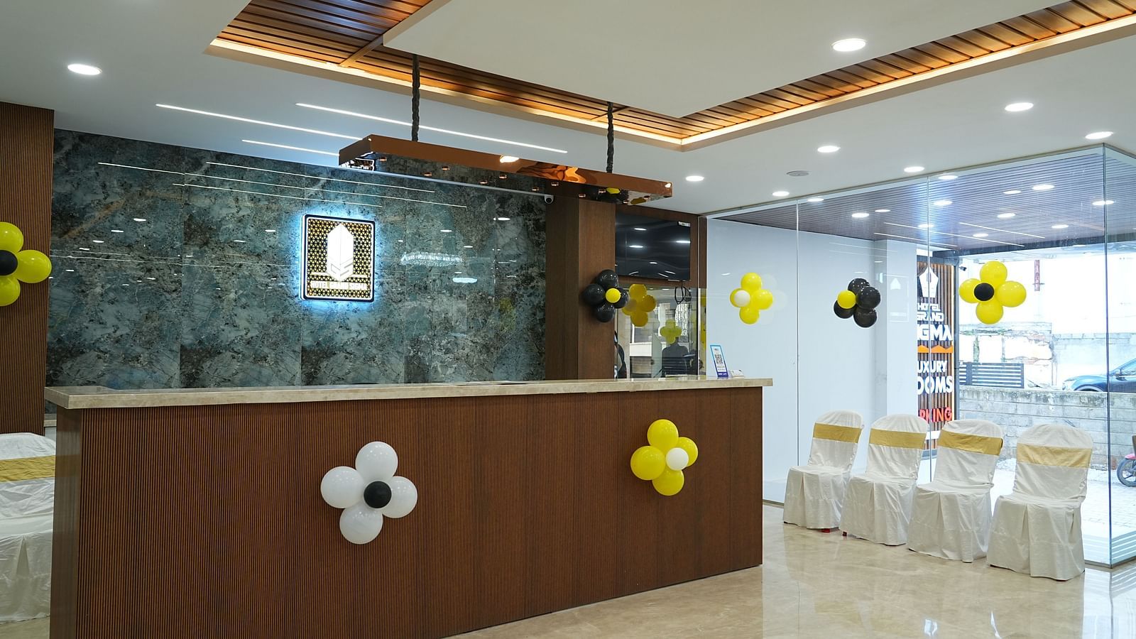 side angle view of the reception area with four chairs kept in the side - Hotel Grand Sigma