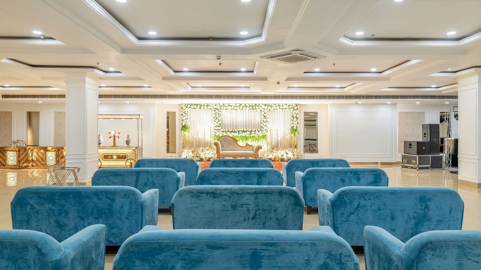 Comfortable blue lounge seating in a large, elegant banquet hall at Hotel Highway King, Bilaspur.