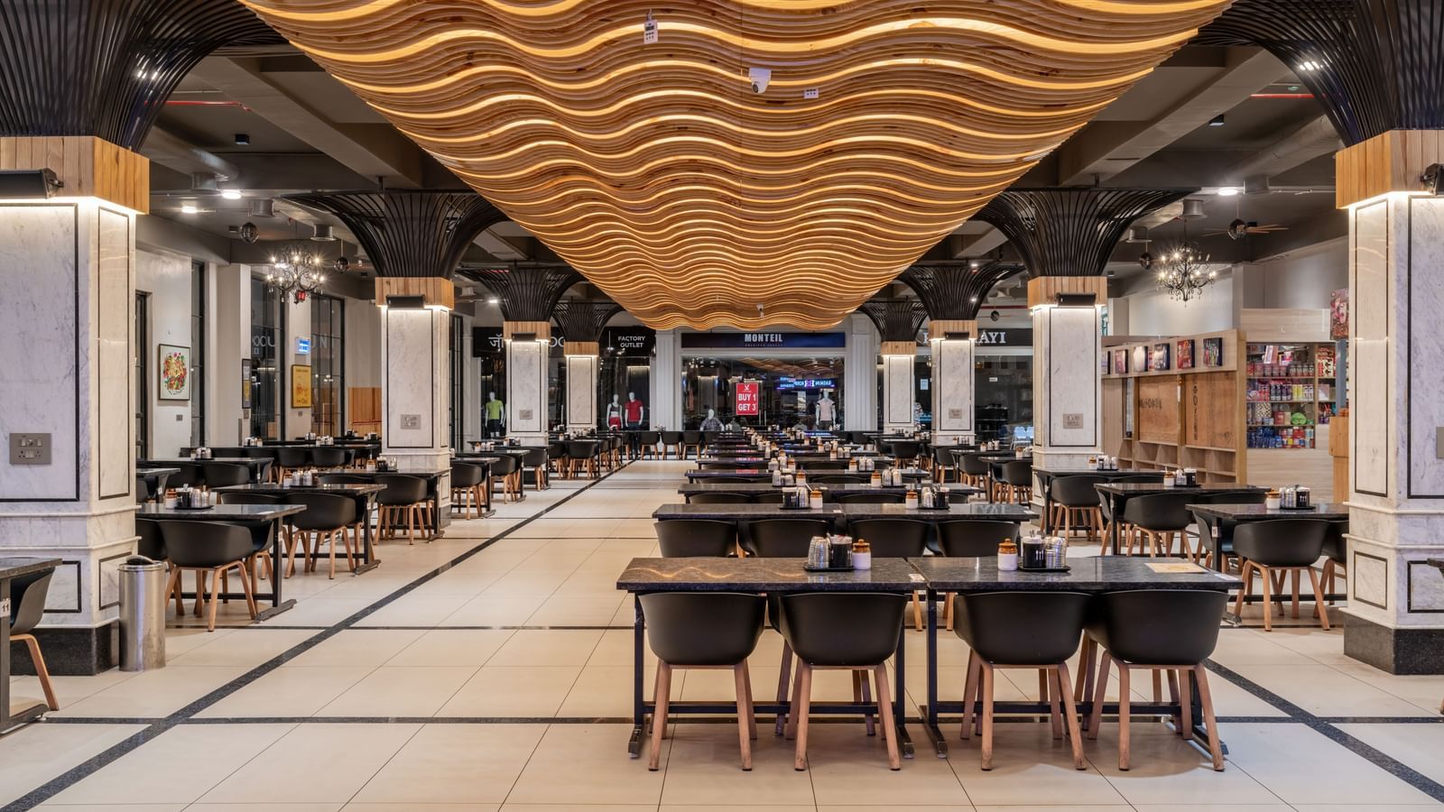 The interior of the dining area at Hotel Highway King, Kishangarh, featuring rows of seating and ambient lighting.