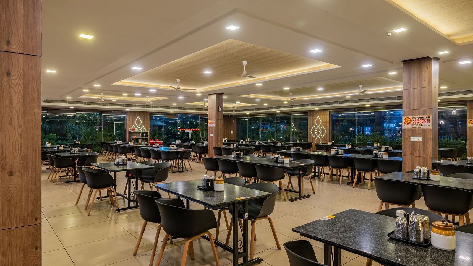 A closer perspective of the well-arranged dining area at Hotel Highway King Shahpura, showing many tables.