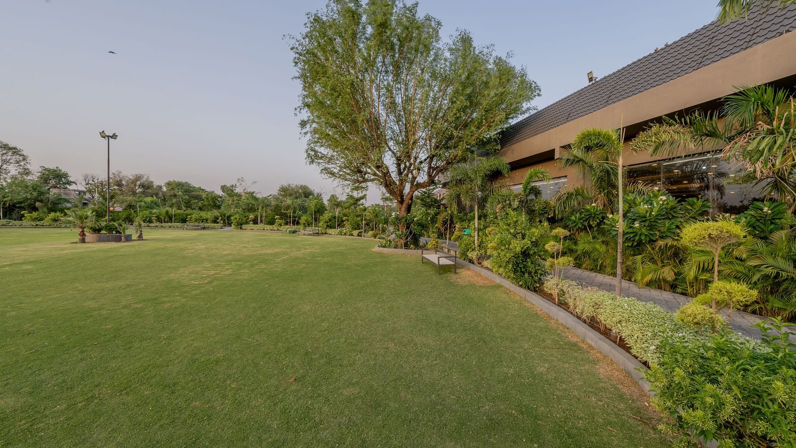 The pool deck with lounge chairs and lush landscaping at Hotel Highway King Shahpura.