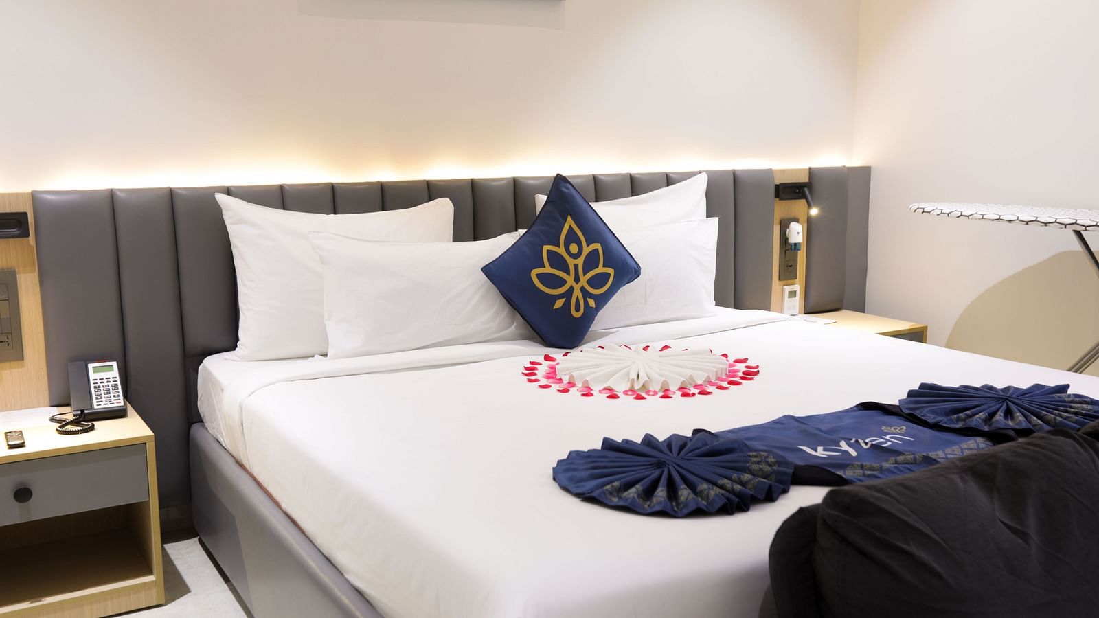 A double bed with towel art, frame and bedside table at Hotel Kyzen HiTech City – Your Zenly Stay.