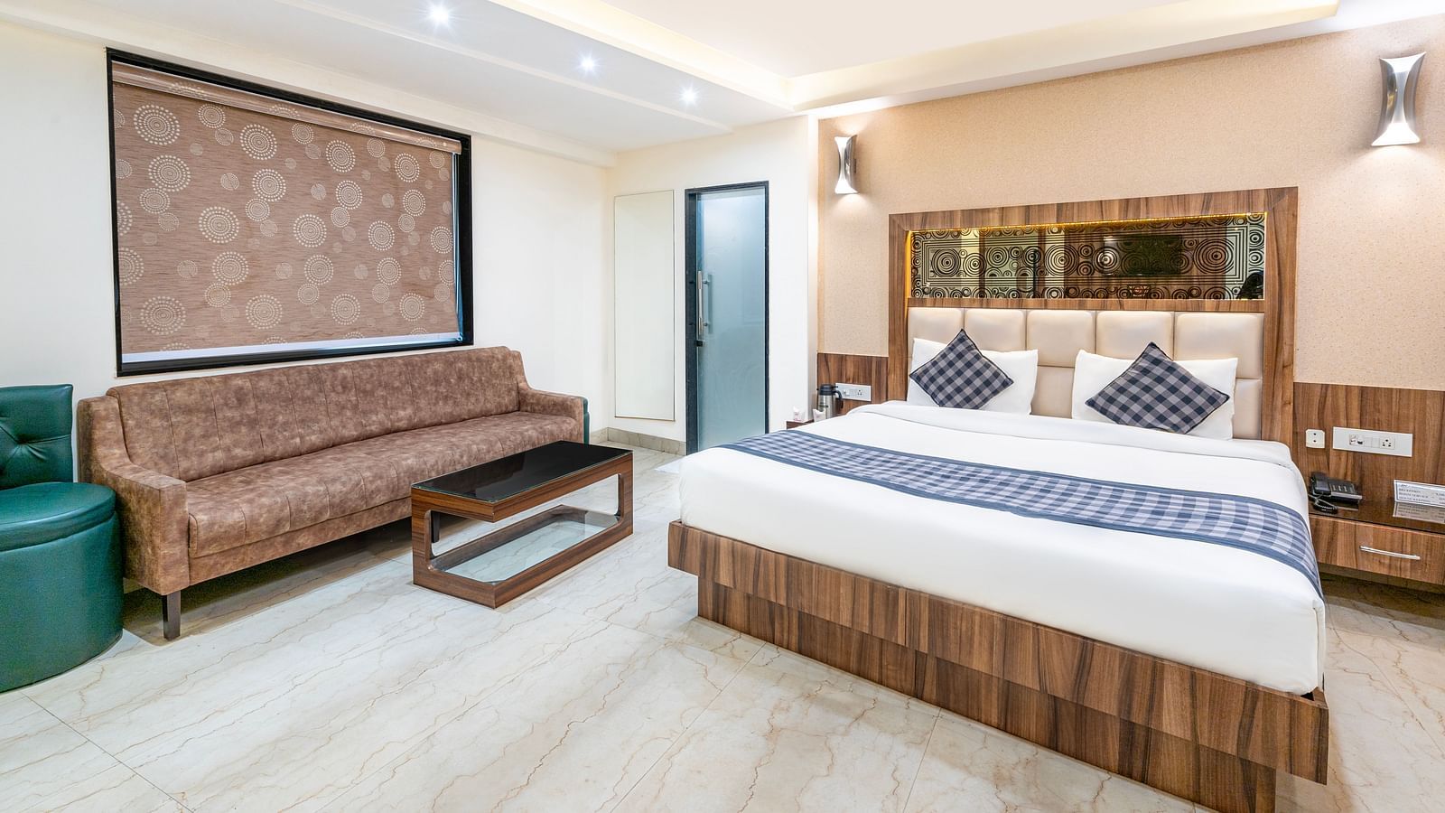A side angle image of the room at Hotel Moti Palace, showcasing a regal feel with a king-size bed.