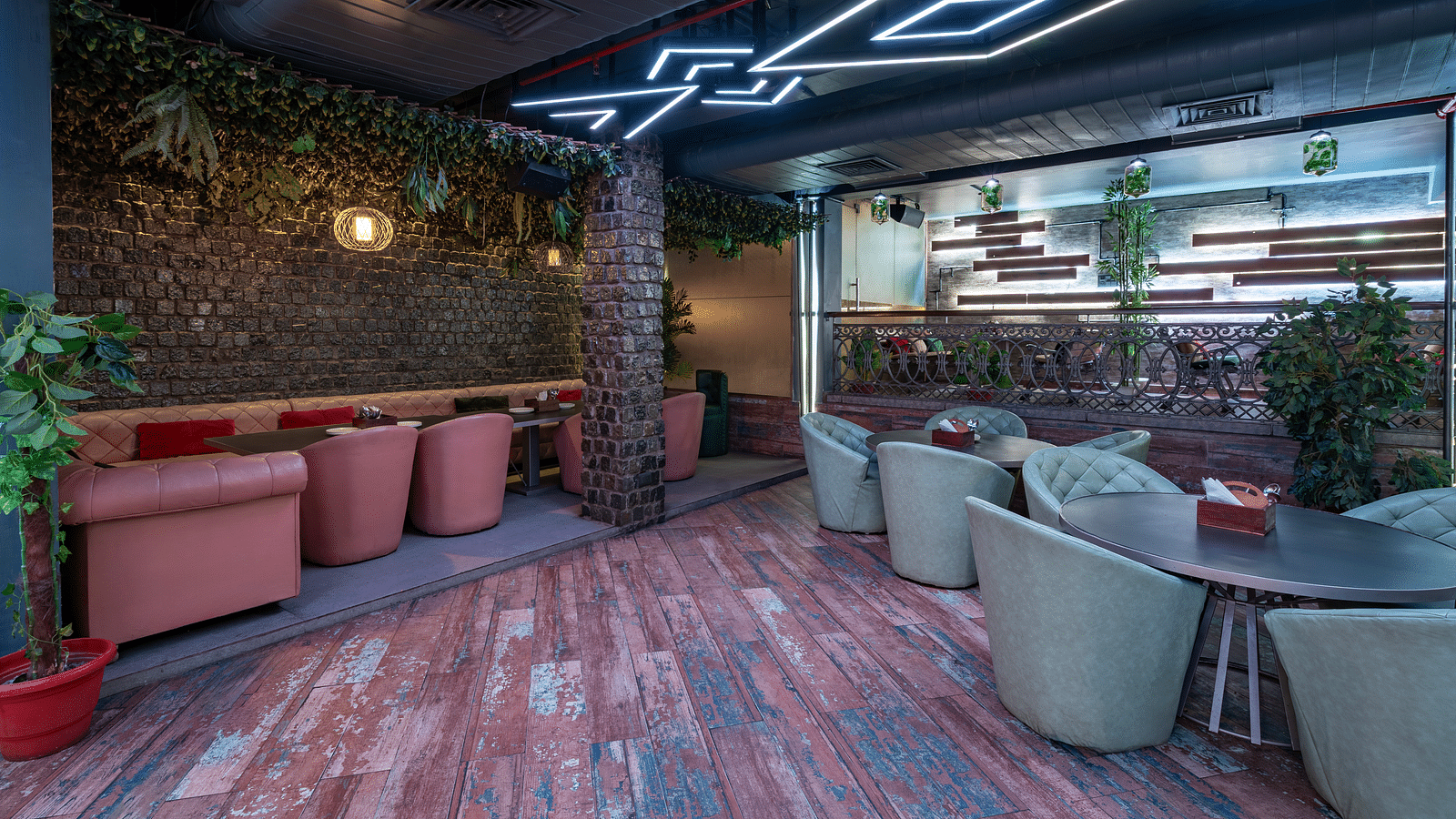 Interior view of the restaurant at Hotel Moti Palace, featuring comfy sofas, warm ambient lighting, and decor with lush plants