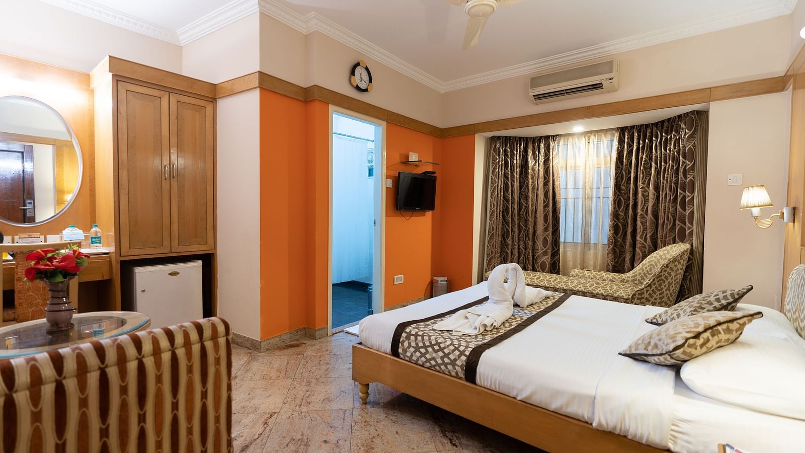 a double bed with a tv opposite it inside one of the rooms - Hotel Pai Comforts, JP Nagar