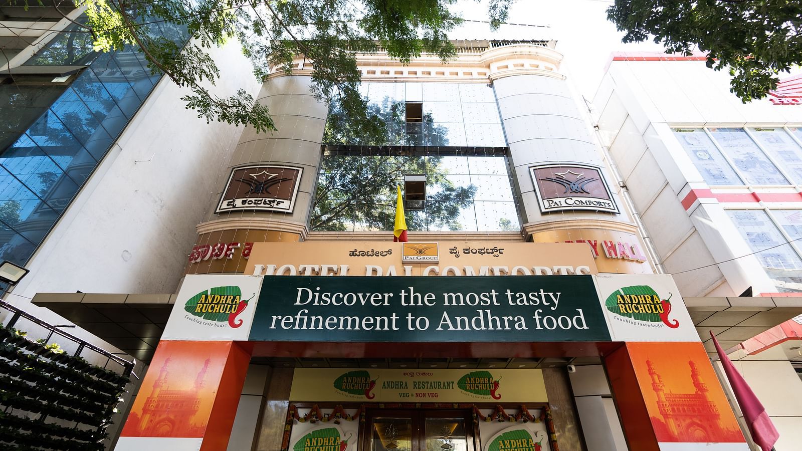 facade image of Hotel Pai Comforts, JP Nagar with tree branches above