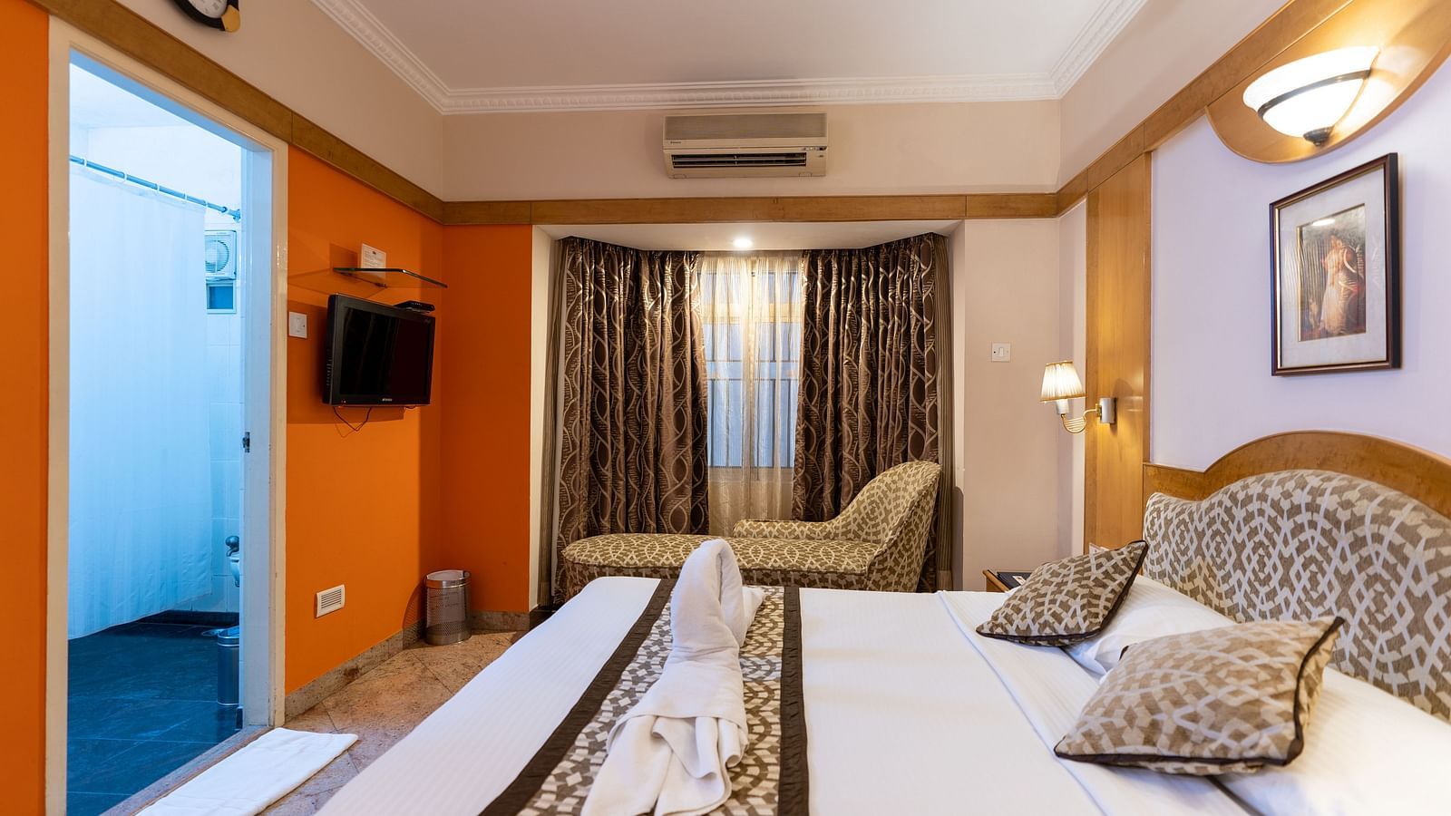 a double bed with a cushioned headboard inside one of the rooms - Hotel Pai Comforts, JP Nagar