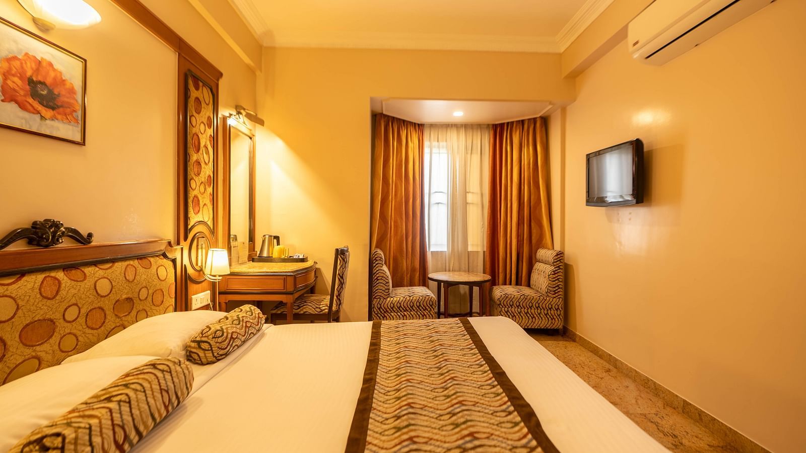 The Executive Room at Hotel Pai Viceroy Jayanagar featuring warm interiors and a queen sized bed amongst other amenities