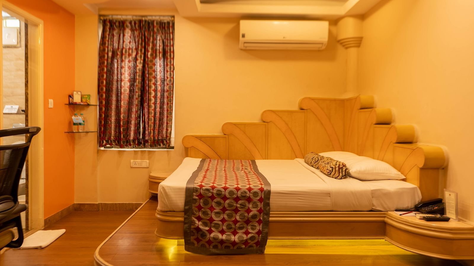 The suite at Hotel Pai Viceroy Jayanagar featuring warm interiors and a queen sized bed