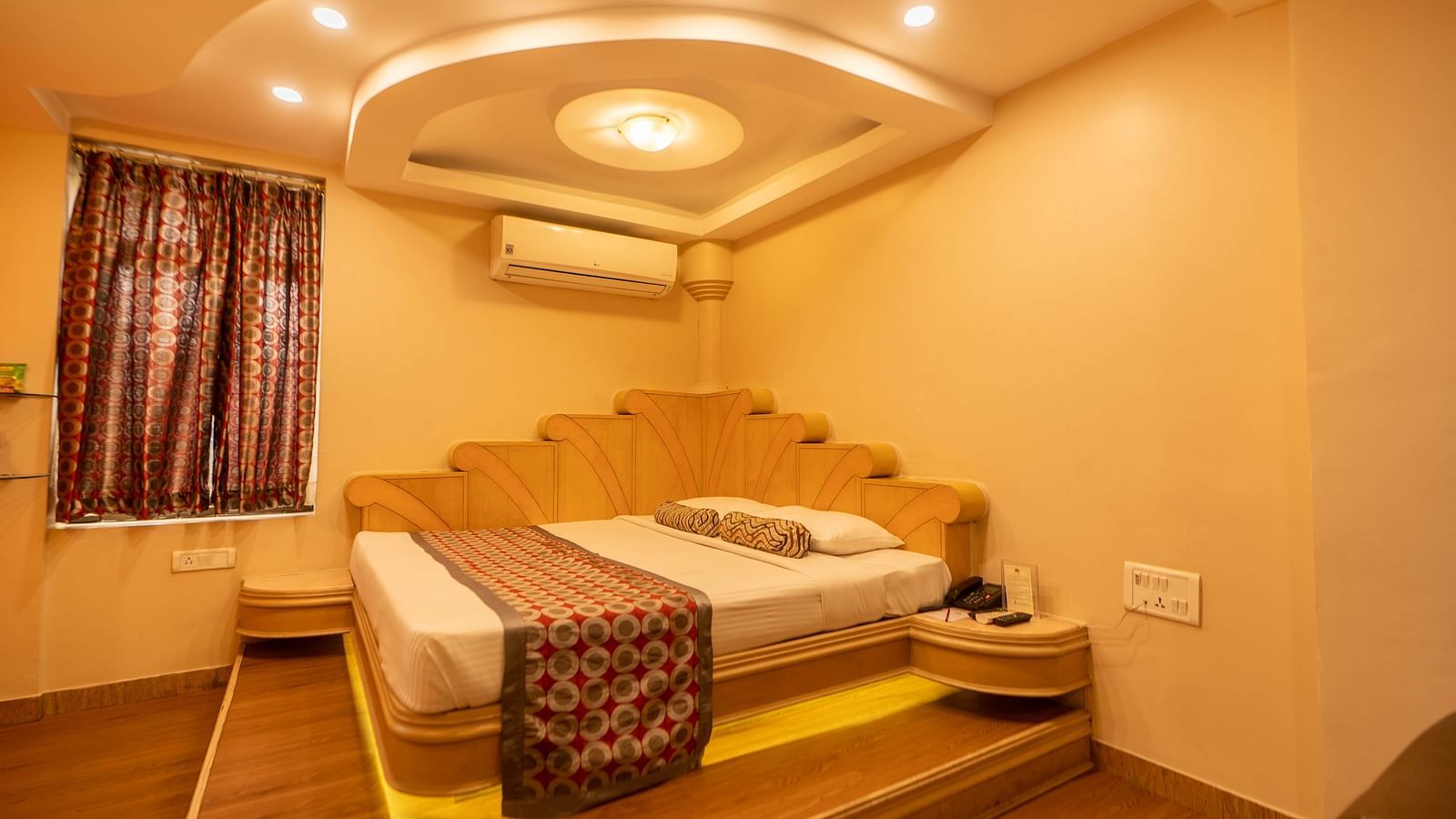 The suite at Hotel Pai Viceroy Jayanagar featuring warm interiors and a queen sized bed