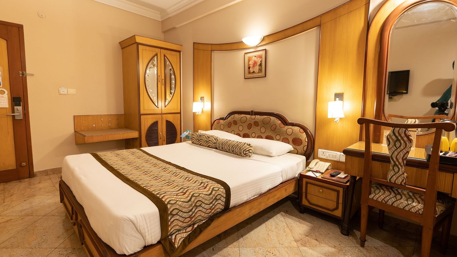 The Executive Room at Hotel Pai Viceroy Jayanagar featuring a queen sized bed, dressing table, and a mirror amongst other amenities