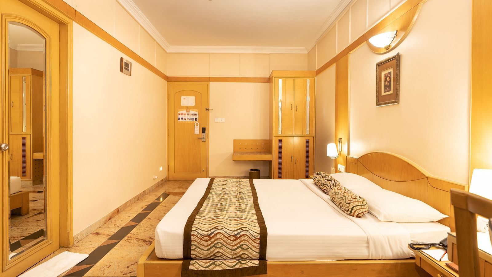 The executive room at Hotel Pai Viceroy Jayanagar featuring warm interiors and a queen size bed