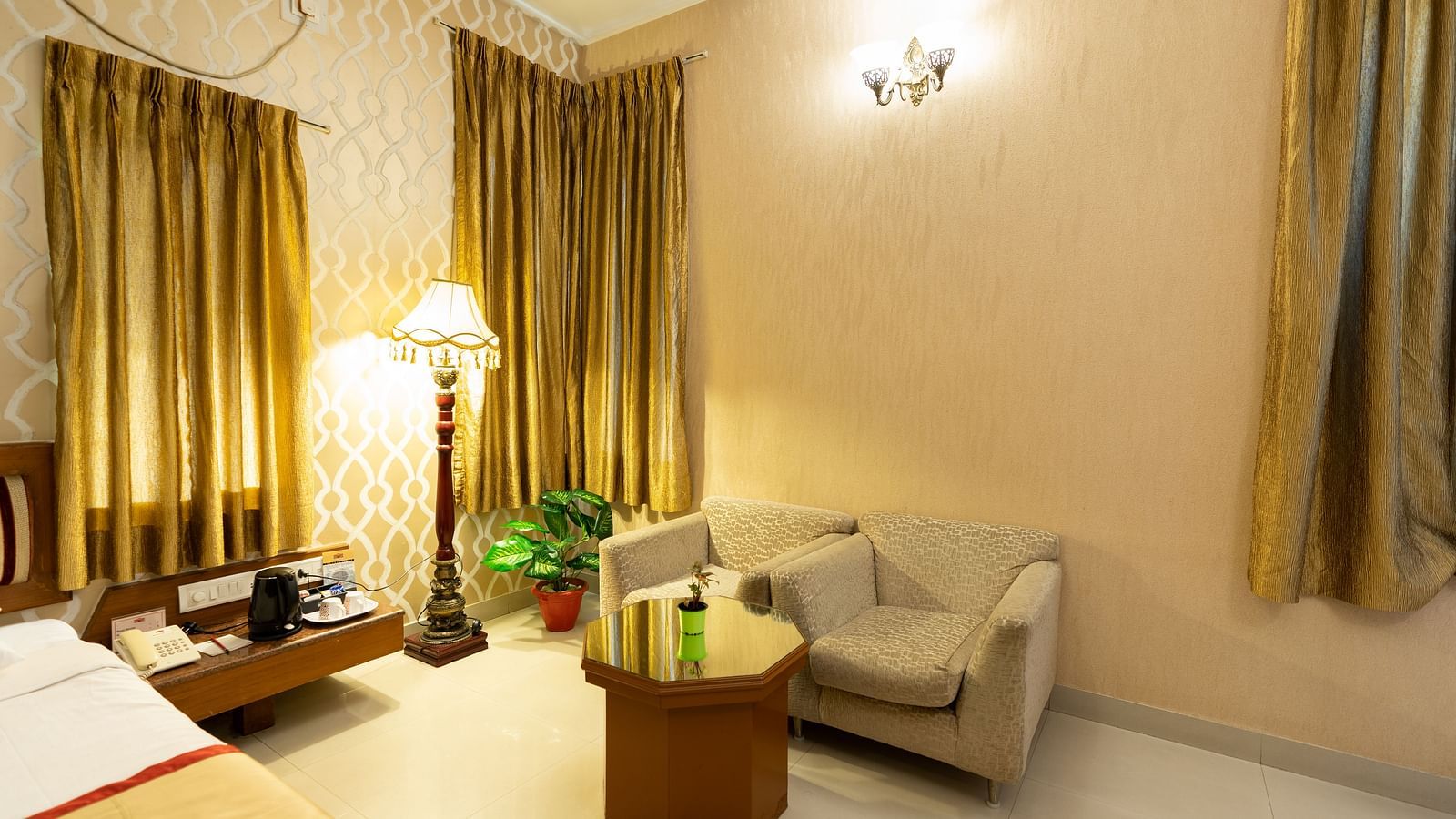 A sofa on the side of a double bed inside one of the rooms - Hotel Pai Vista, KR Road