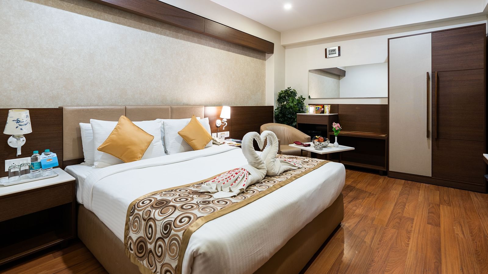 a double bed with dove towels on it inside one of the rooms - Hotel Pai Vista, Mysore