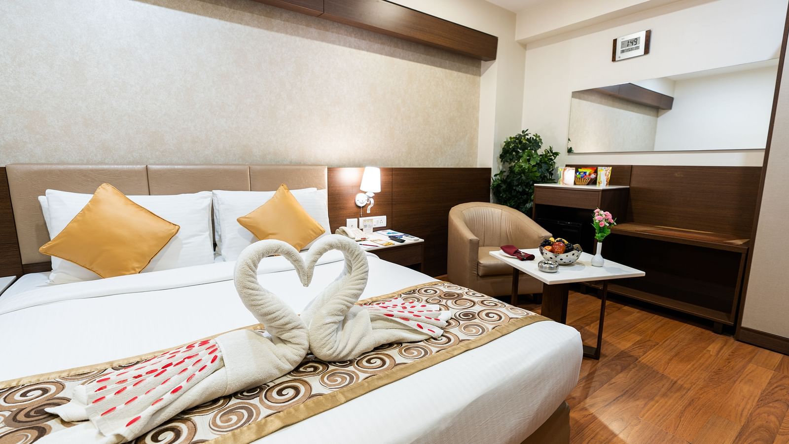 a double bed with a single seater sofa next to it inside one of the rooms - Hotel Pai Vista, Mysore