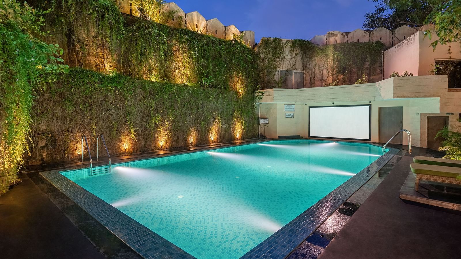 Shot of the swimming pool at the hotel in the evening with well lit surroundings - Hotel Rajdarshan, Udaipur.