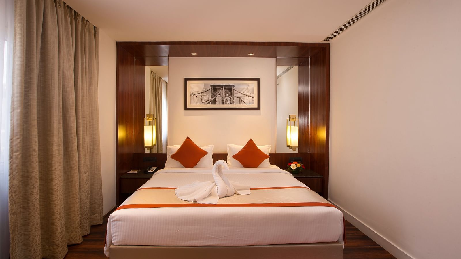A hotel room featuring a large bed with white linens and red accents, a desk and a wall-mounted TV - Hotel Southend by TGI - Bommasandra, Bangalore