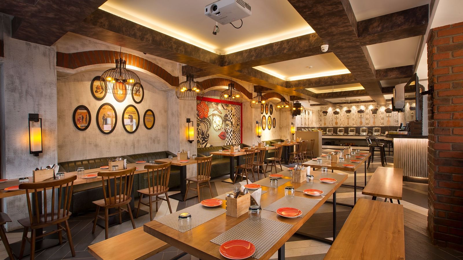 A cosy restaurant interior with wooden tables, pendant lighting and a buffet area in the background - Hotel Southend by TGI - Bommasandra, Bangalore