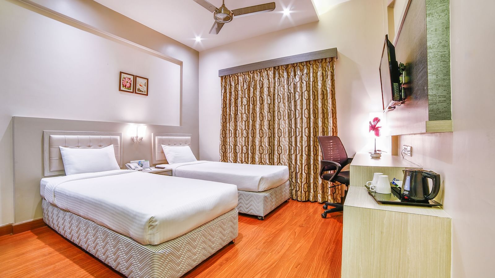 A neat hotel room with two large beds, a study desk, and ambient lighting. - Tara, Comfort Hotel in Hyderabad - Ramoji Film City.