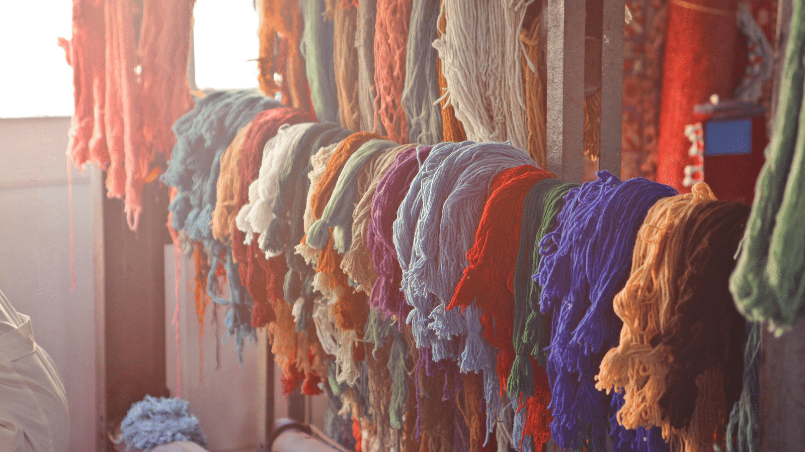 Various colorful threads hanging on rail in workshop