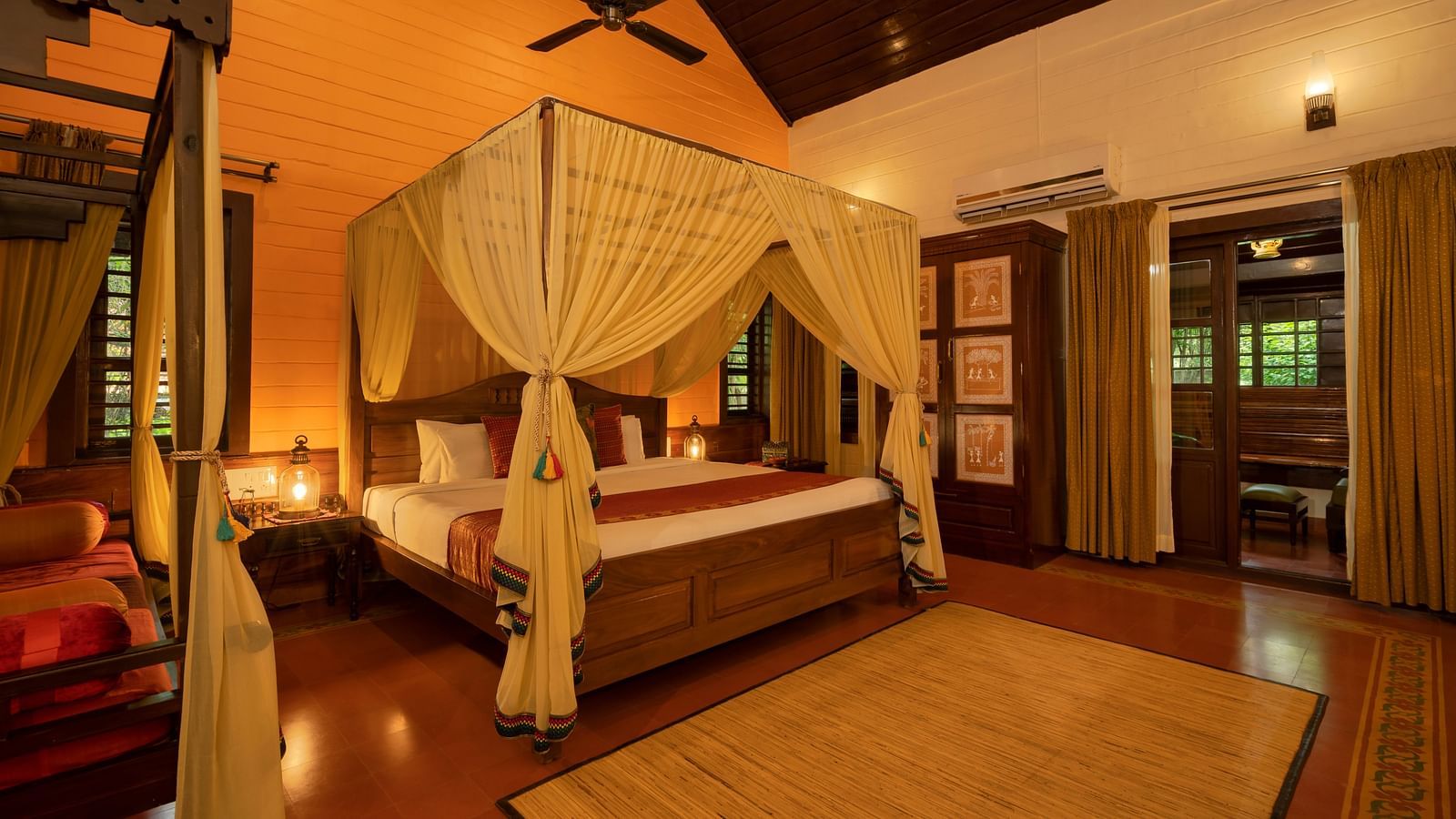 An image of a bedroom with seating area, open windows, lamp, dressing table, etc. -  Hoysala Village Resort, Hassan