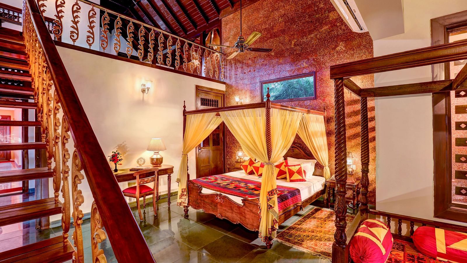 An image of a bedroom with two poster beds and a wooden stair leading to the attic of the room - Hoysala Village Resort, Hassan