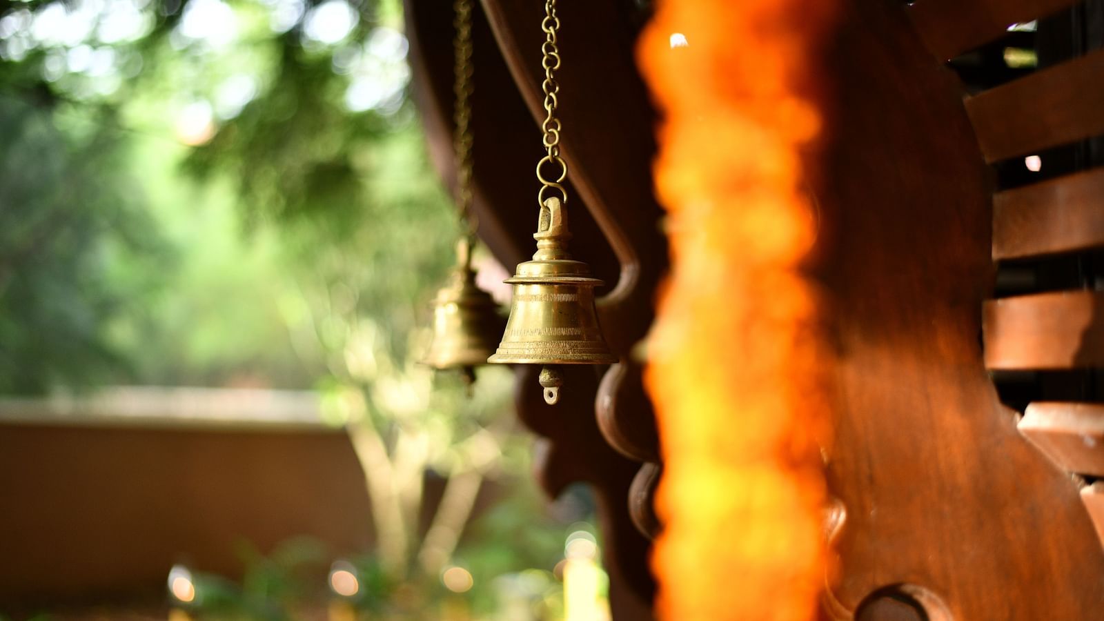 image of bronze bells with bright sunlightat Hoysala Village Resort, Hassan