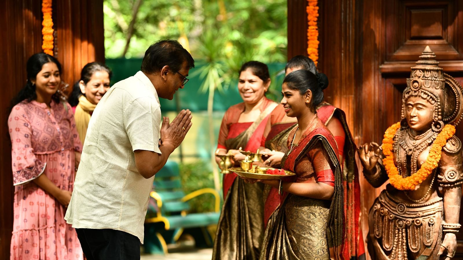 staff welcoming guests with tilak at Hoysala Village Resort, Hassan