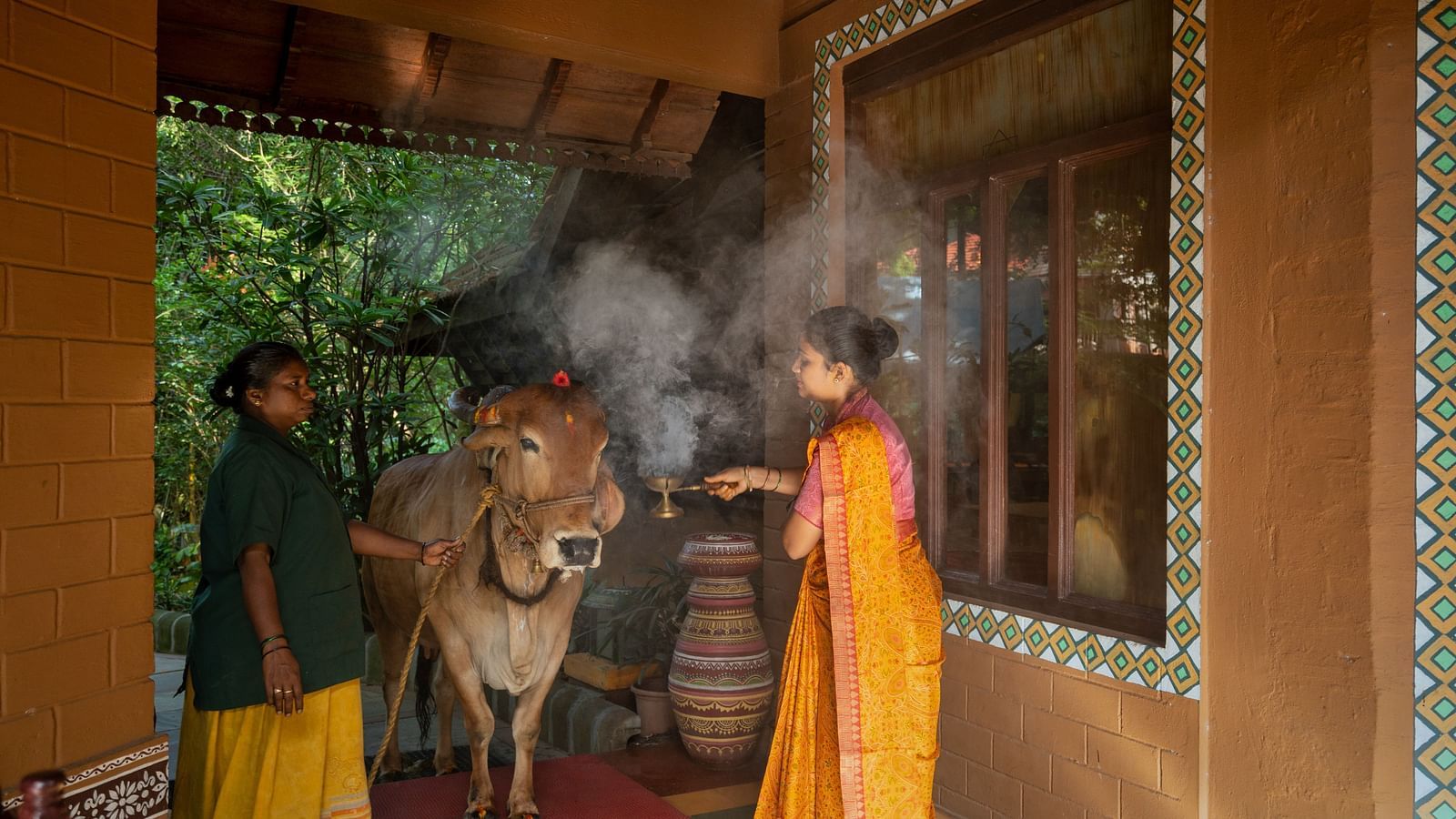 staff worshipping the divine cow at hoysala village resort, hassan.