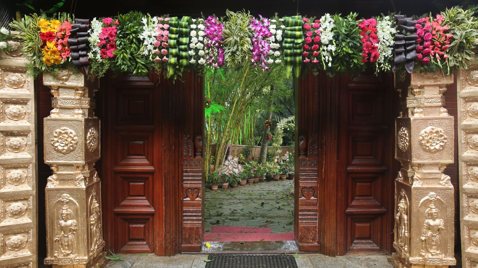 image of an entrence at hoysala village resort decorated with pillars and flowers in a very beautiful manner for a wedding