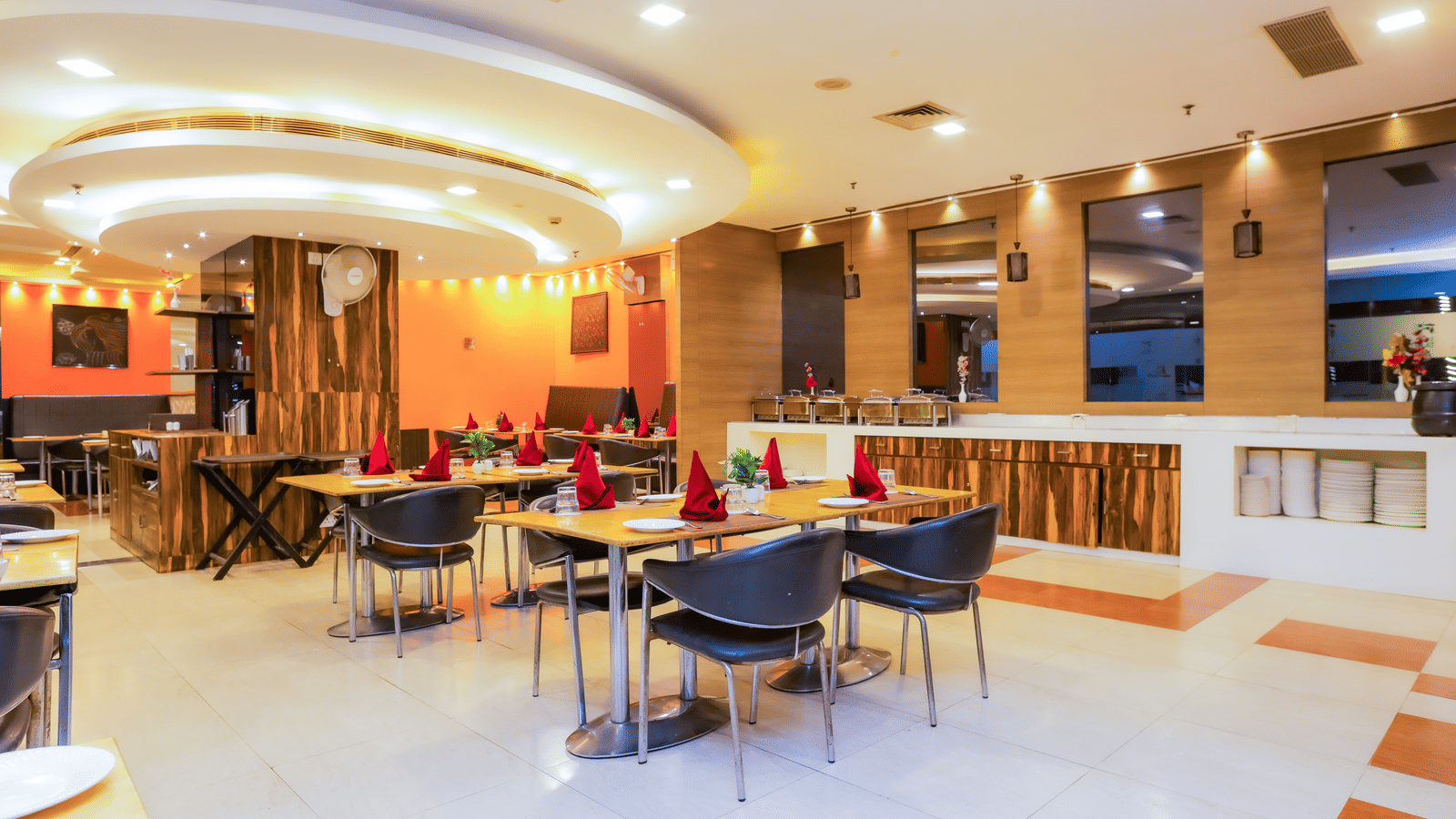 Dining area at Cafe Treat with simple seating arrangement and modern interiors with ambient lighting.