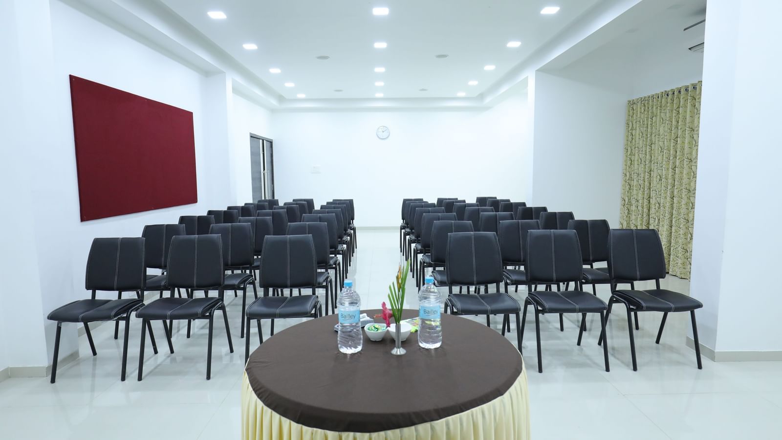 A conference room at Imperial Grande with rows of black chairs facing a small round table in the foreground.