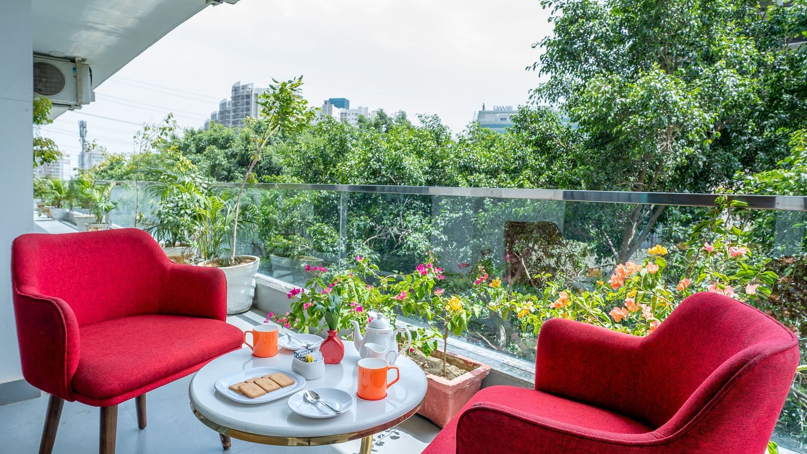 An image of a sitting area at the balcony with one centre table and two chairs | Inde Hotel Golf Course Extension