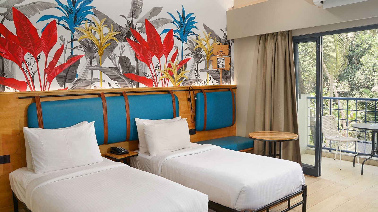 An image of a bedroom with twin beds, AC, and a balcony attached to it at Indie Stays Studio, Chembur