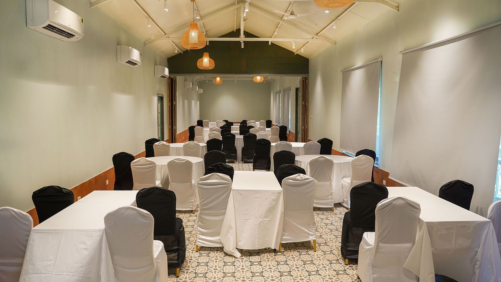  A banquet hall with a circular table surrounded by chairs, and lighting set for celebrations at Indie Stay
