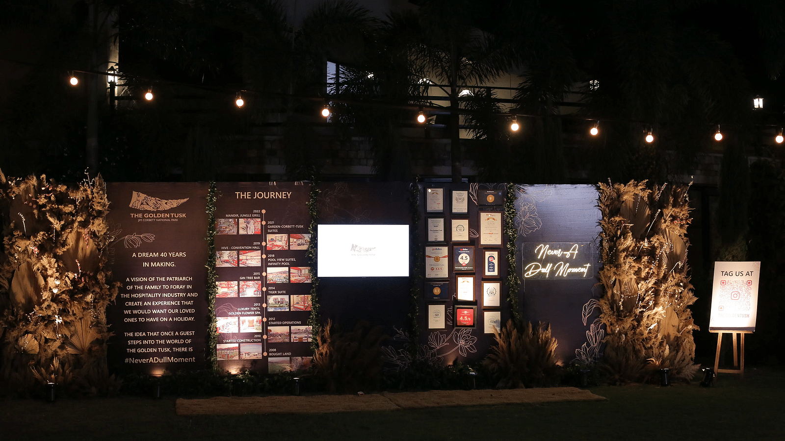 A dimly lit stage with various awards on display along with the venues of the Golden Tusk Resort.