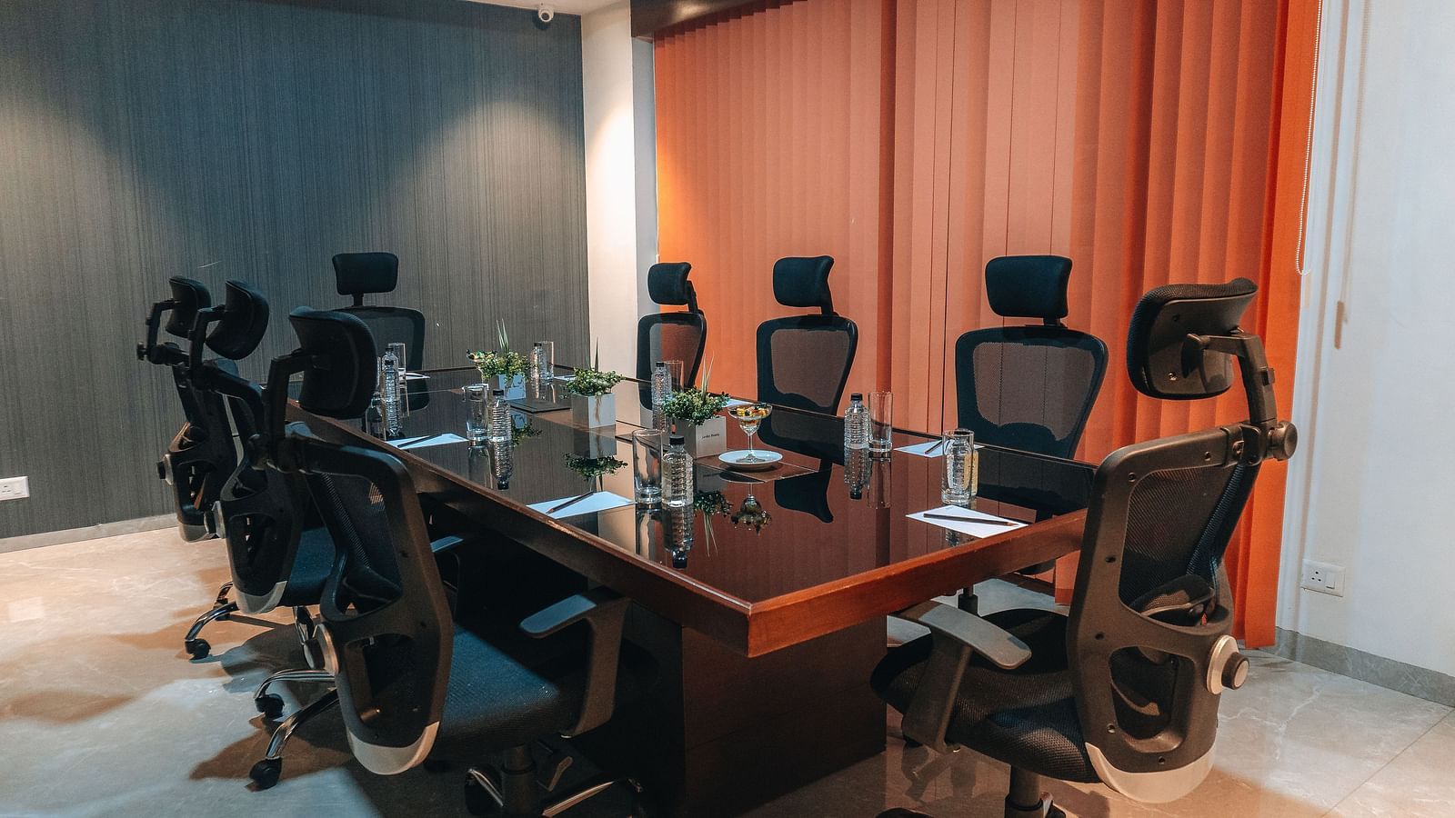 a meeting room with chairs kept around a rectangular table - Jardin Hotels, Indore