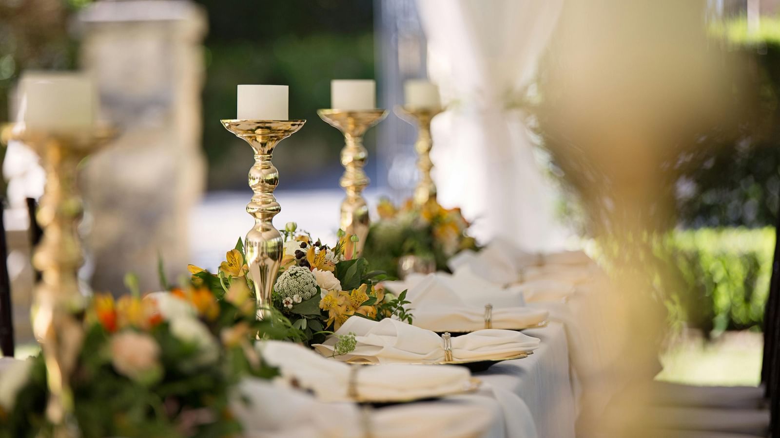 a long dining table set outdoors with decorations
