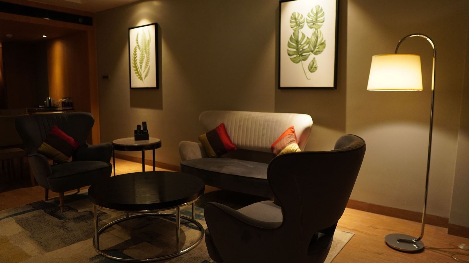 Cosy sofa and a standing lamp in the corner of Grand Suite at Kiranshree