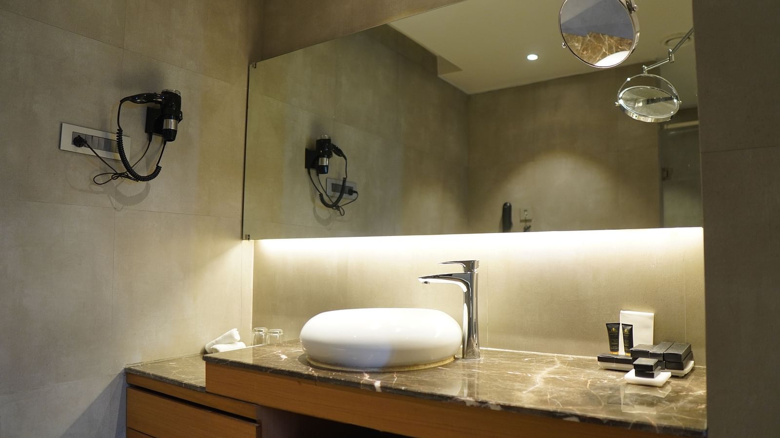Spacious bathroom with a large rectangular mirror and warm lighting
