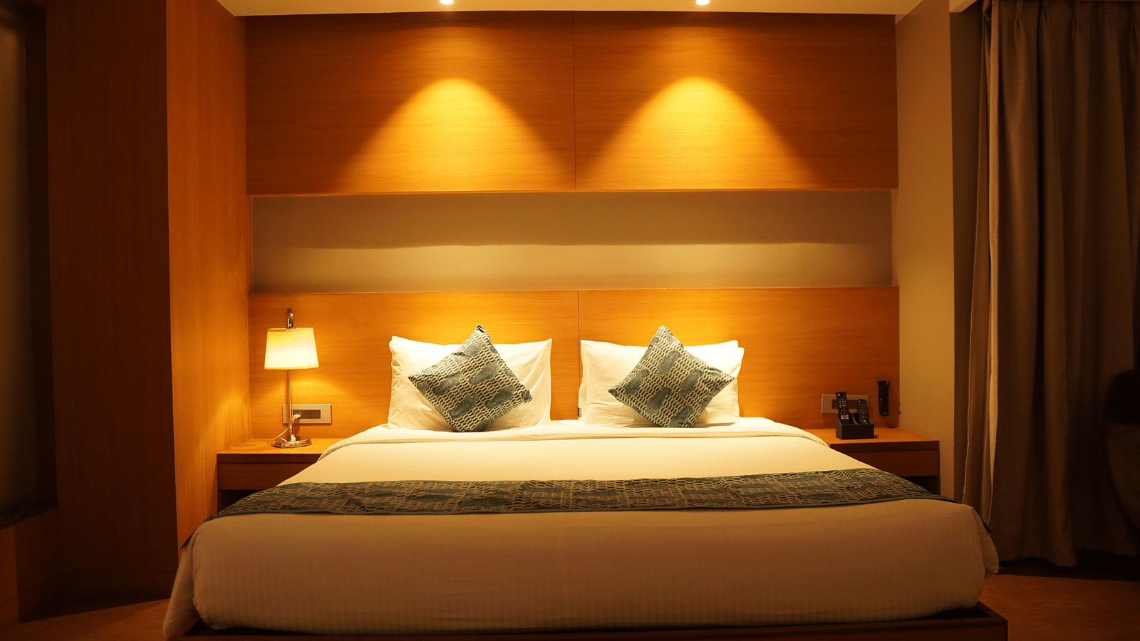 Front view of the bed with warm lighting and bedside tables on either side.