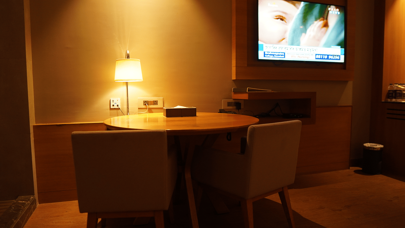 Spacious wooden table with a table lamp and wall-mounted television