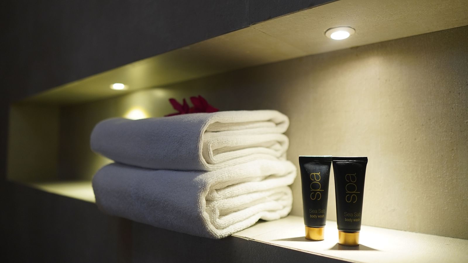 Towels neatly folded, with tubes of essentials placed nearby