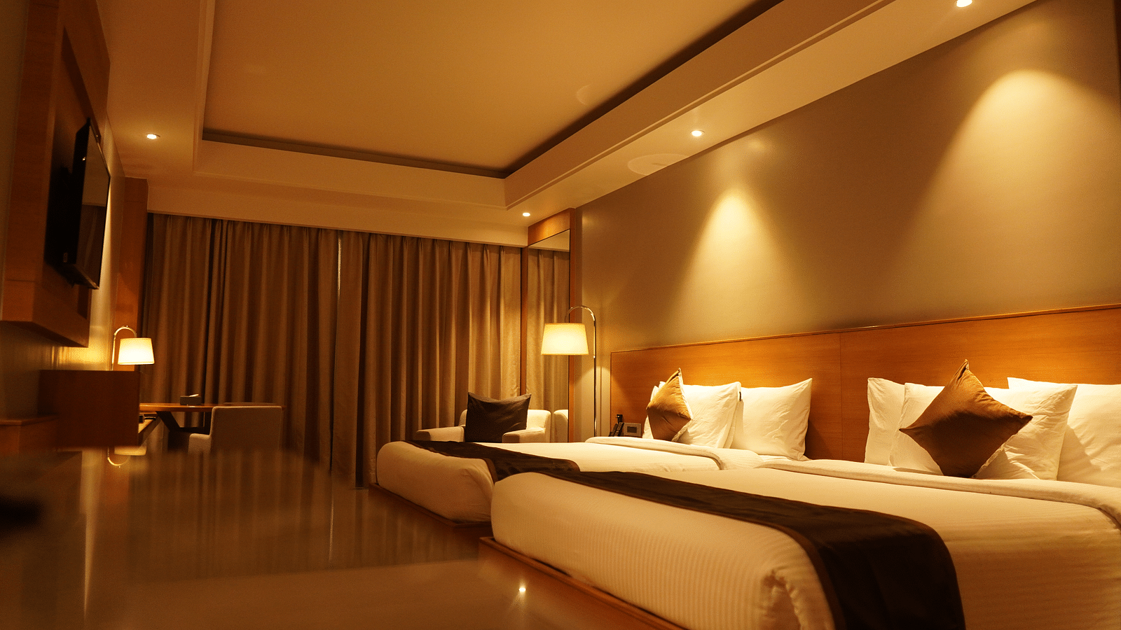 Two spacious beds with warm lighting and neatly made sheets