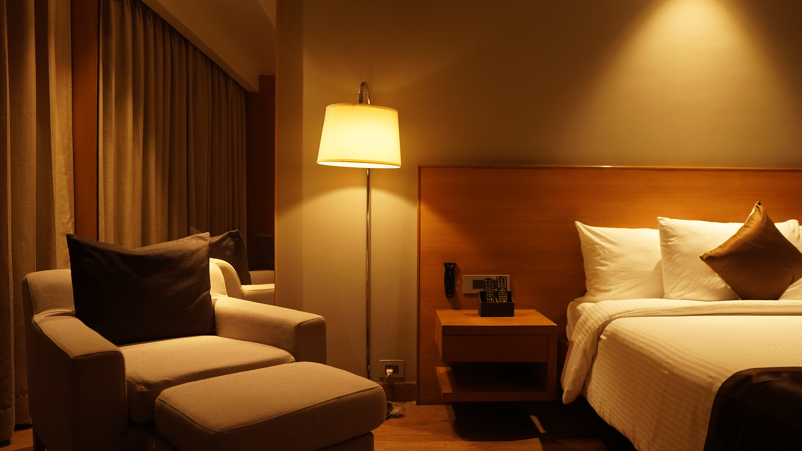 Spacious bed with warm lighting and cushioned seating furniture
