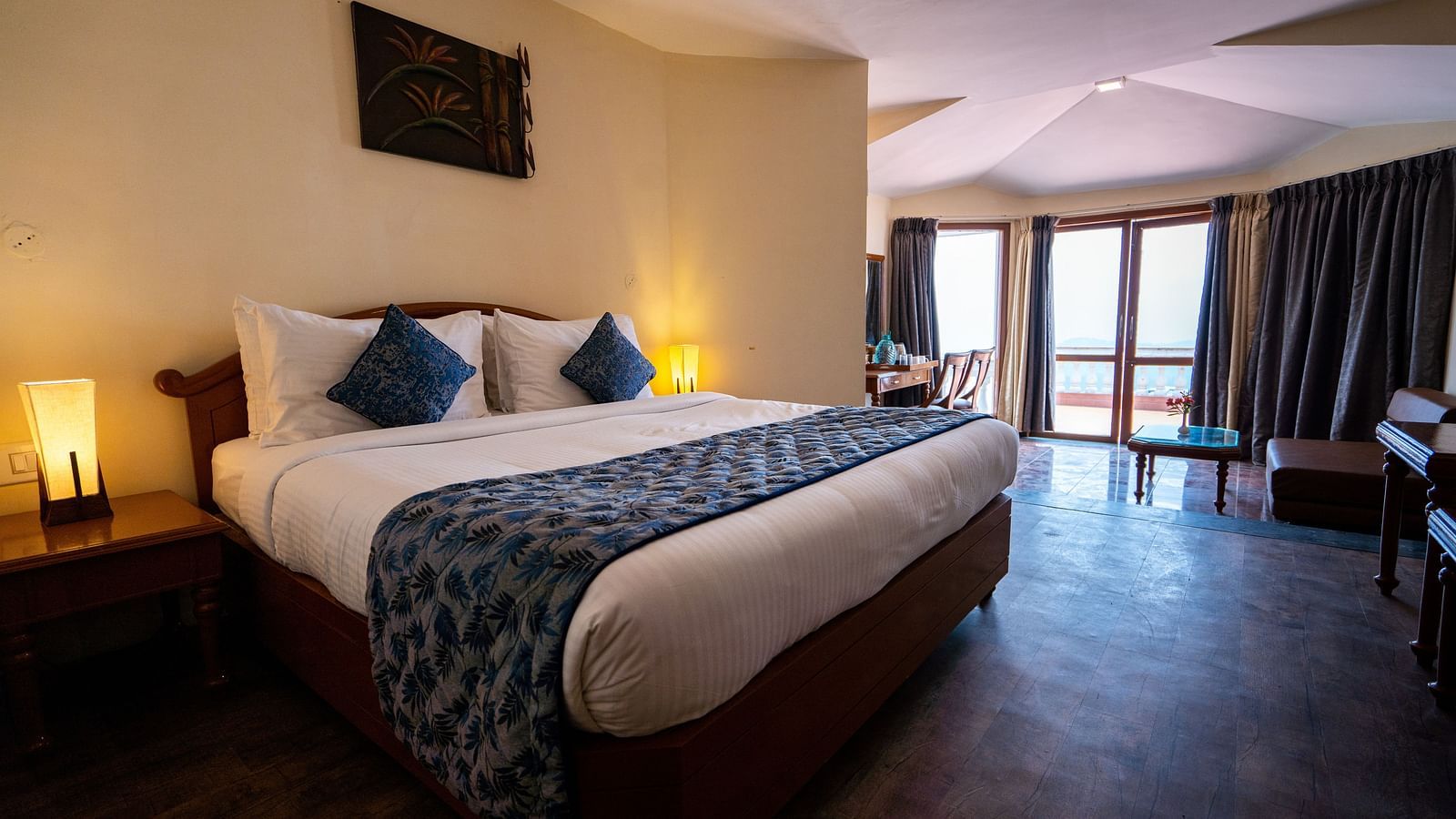 comfy bed with blue duvet and pillows at La Montana By TGI, Ooty