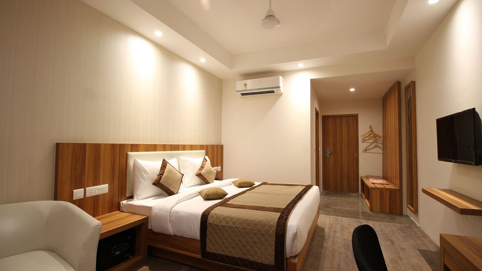 Corporate room with a posh bed and warm lighting captured from different angles while showcasing the in-3room amenities - the Le Roi Raipur Hotel